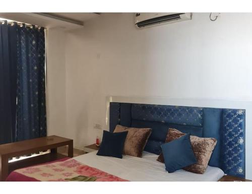 uma cama com uma cabeceira azul num quarto em Hotel Abhinandan, Paonta Sahib em Pāonta Sāhib