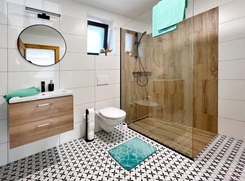 uma casa de banho com um chuveiro, um WC e um lavatório. em JUNÁK ubytování v soukromí em Vranov nad Dyjí