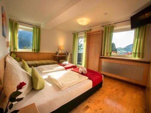 a bedroom with two beds and a couch and windows at sWiesers in Piesendorf