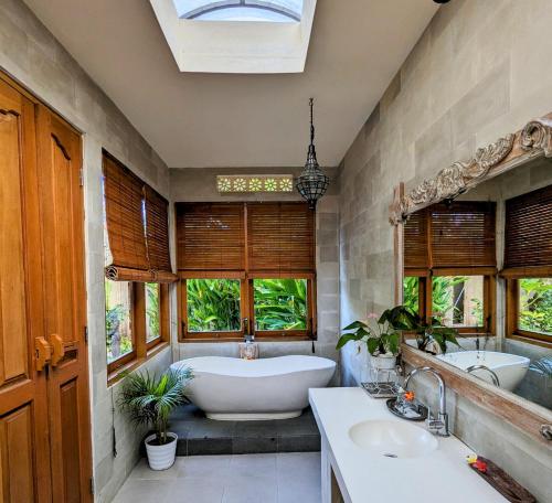 uma casa de banho com 2 lavatórios, uma banheira e janelas em Villa Ulun Mertha - 1BR Private Villa em Ubud