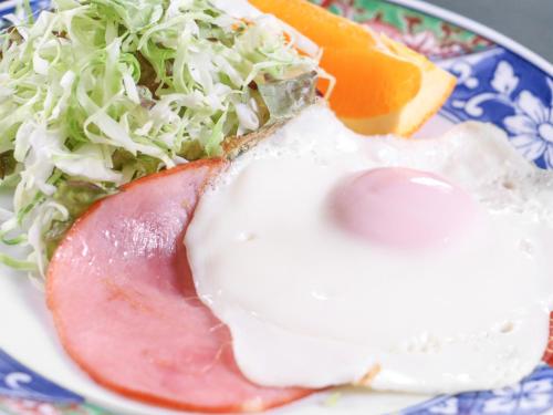 a plate of food with an egg and a salad at サンバレーひぐち in Muikamachi