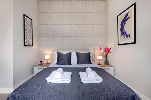a bedroom with a bed with two white towels on it at Contemporary Clapham Living in London