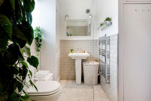 La salle de bains est pourvue de toilettes et d'un lavabo. dans l'établissement Contemporary Clapham Living, à Londres