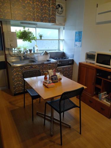a kitchen with a table and two chairs and a sink at Private Room in Japanese Vintage House 民家の一室 Smoke Free, Free Parking Good to Travel for Tashiro Cats Island no1 in Ishinomaki