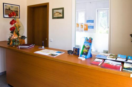 a desk with books and a vase of flowers on it at Gästehaus zur Kurve in Zirndorf