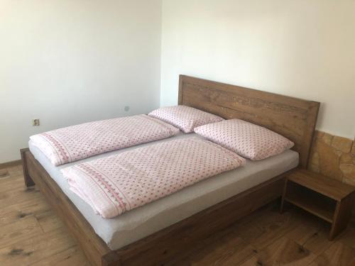 Una cama con dos almohadas rosas encima. en Relax 38 en Prievidza