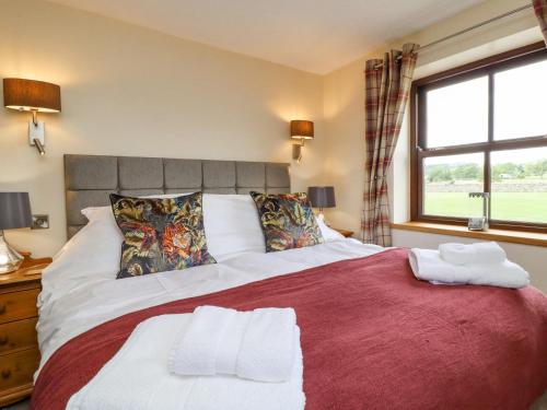 a bedroom with a large bed with two towels on it at Orcaber Farmhouse in Lancaster