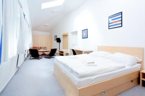 a bedroom with a bed and a desk with chairs at Penzion Kraličák in Staré Město