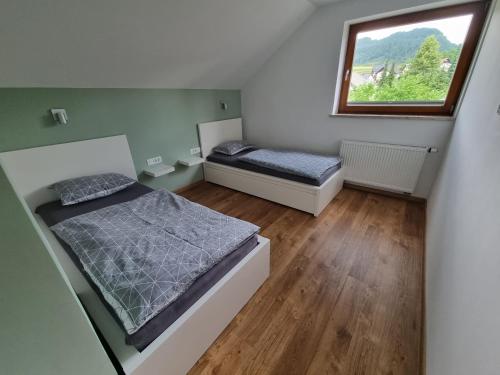 a small bedroom with two beds and a window at Apartment 199 in Zgornje Gorje