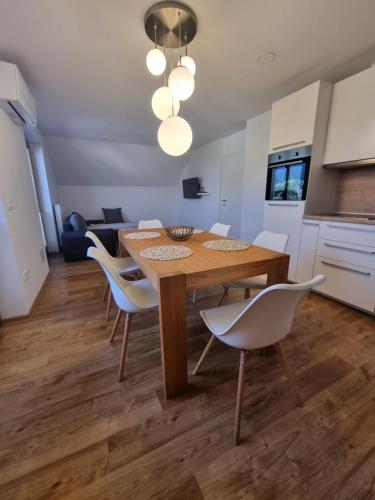 uma cozinha e sala de jantar com uma mesa de madeira e cadeiras em Apartment 199 em Zgornje Gorje