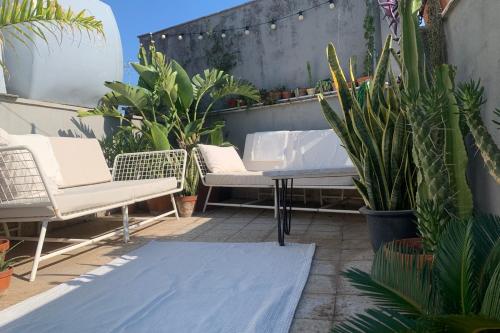 a patio with chairs and potted plants on a balcony at Homestay in Catania