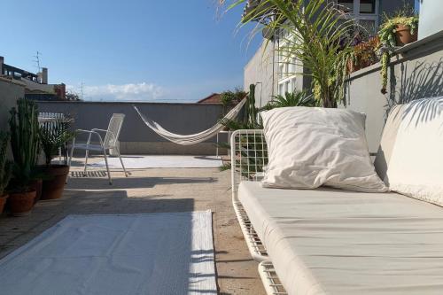 a white couch sitting on a balcony with a hammock at Homestay in Catania