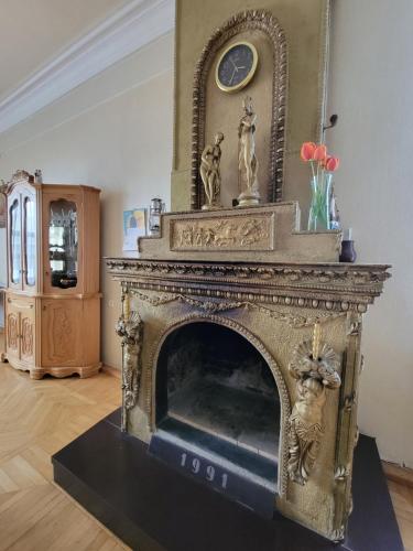 an ornate fireplace in a living room with a clock at B&B Odzun in Odzun