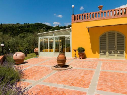 un patio de una casa con un edificio amarillo en Bright Farmhouse in Montecatini Terme with Swimming Pool, en Pieve a Nievole