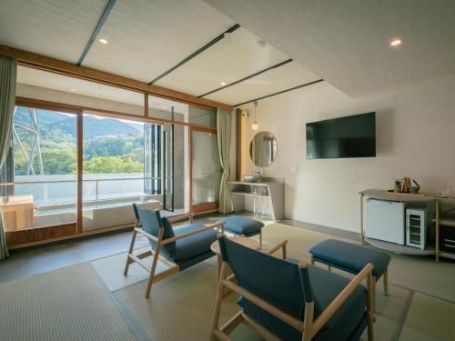 uma sala de estar com cadeiras e uma grande janela em 巛-sen-湯河原 em Yugawara