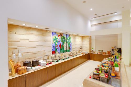 a restaurant with a counter with food on display at Lemon Tree Premier 1, Gurugram in Gurgaon