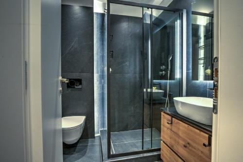 a bathroom with two sinks and a glass shower at The Cosy luxurious Seaside Apartment in Athens