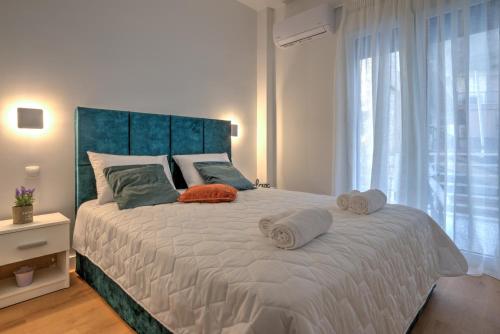 a bedroom with a large bed with towels on it at The Cosy luxurious Seaside Apartment in Athens