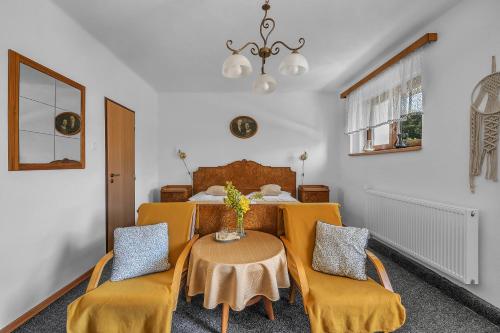 Habitación con mesa, sillas y cama en Hotel Podkost en Libošovice