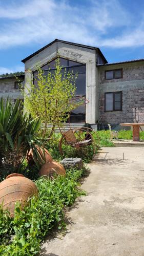 a building with plants and a bench in front of it at B&B Odzun in Odzun