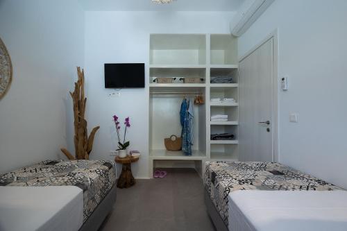 two beds in a room with white walls at OLIVES seaside villas villa no 2 in Plaka