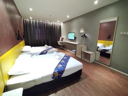 a hotel room with two beds and a mirror at Win Win Boutique Hotel PD in Port Dickson