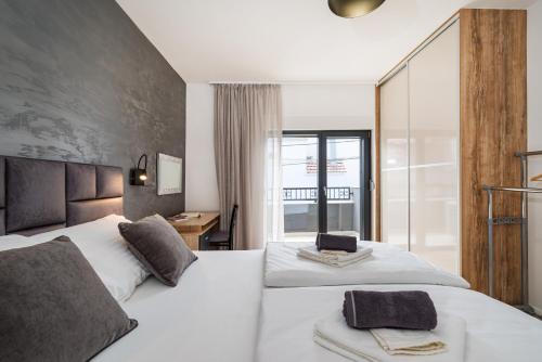 a bedroom with two white beds and a desk at Holiday house Vito Zadar in Zadar