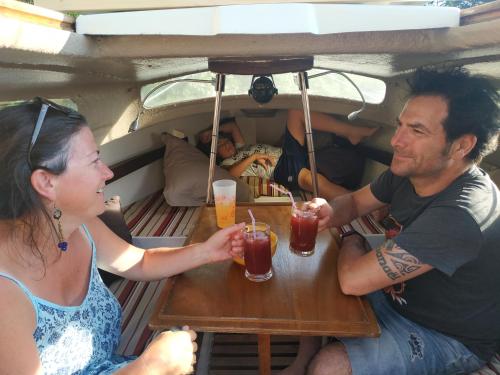 un hombre y una mujer sentados en una mesa con bebidas en Edel de la Touche Balard, en Val Couesnon