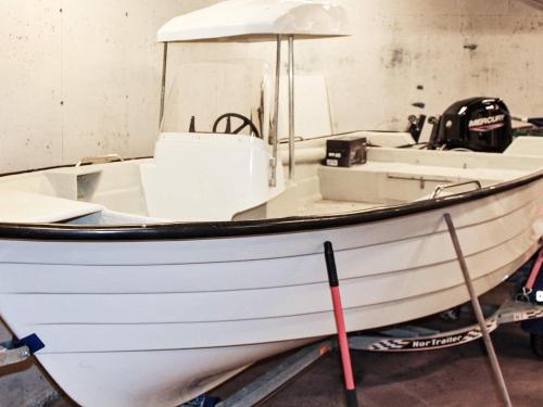 a white boat sitting in a room at Holiday home VATNE III in Vatne