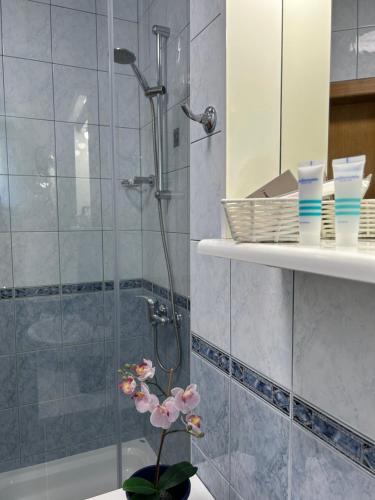 a bathroom with a shower and a vase with a flower at Apartment Natasa in Rab