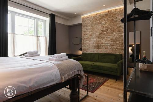 ein Schlafzimmer mit einem Bett und einem grünen Sofa in der Unterkunft StayLagom in Ballycastle