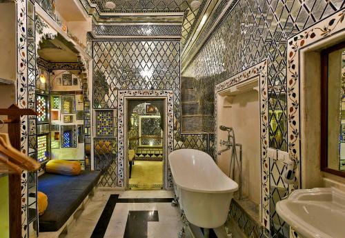 a bathroom with a tub and two sinks in it at Gogunda Palace in Udaipur