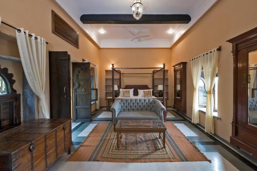 a bedroom with a bed and a table at Gogunda Palace in Udaipur