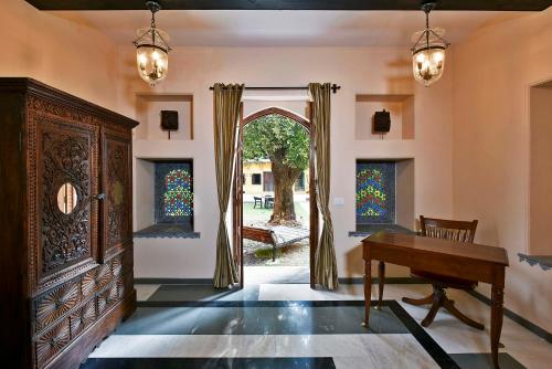 a living room with a piano and an open door at Gogunda Palace in Udaipur