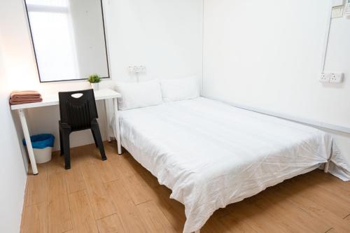 a bedroom with a bed and a desk and a chair at Aimelia guest house in Petaling Jaya