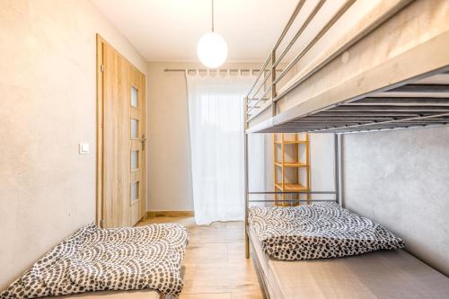 two bunk beds in a room with a hallway at Domki Na Zaciszu in Jastrzębia Góra