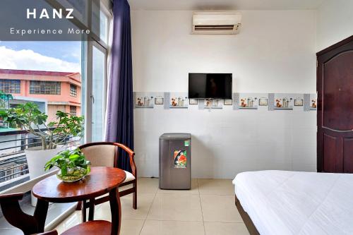 a room with a bed and a table and a tv at HANZ Phuong Thuy Hotel in Ho Chi Minh City