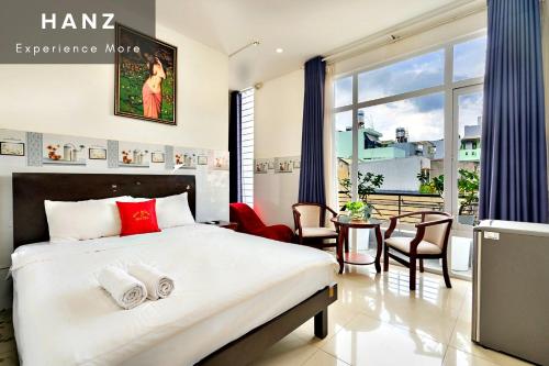 um quarto com uma cama grande, uma mesa e cadeiras em HANZ Phuong Thuy Hotel em Ho Chi Minh