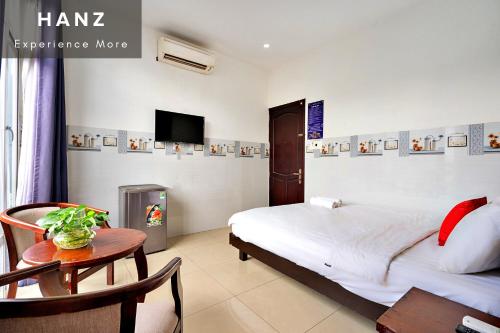 a bedroom with a bed and a table and a tv at HANZ Phuong Thuy Hotel in Ho Chi Minh City
