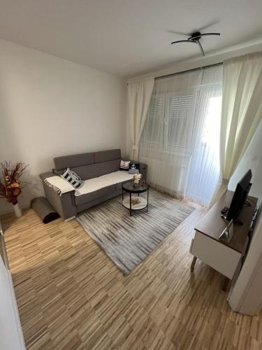 een woonkamer met een bank en een tafel bij Apartman Afrodita in Bosanska Gradiška