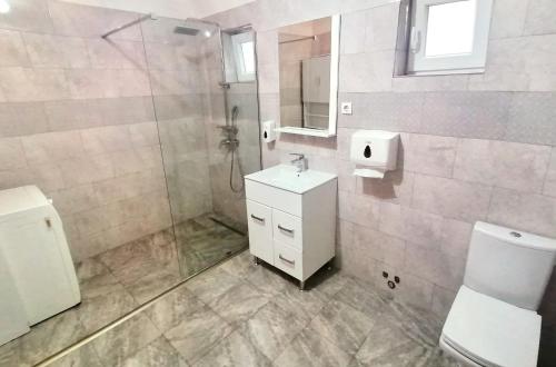 uma casa de banho com um chuveiro, um lavatório e um WC. em Casa Noastră em Cricău