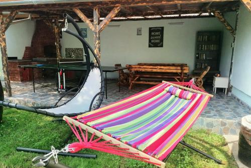 a colorful hammock sitting in the grass in a yard at Casa Noastră in Cricău