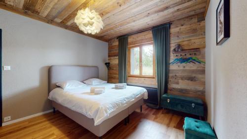 een slaapkamer met een bed en een houten muur bij Contemporary alpine apartment in Anzère in Anzère