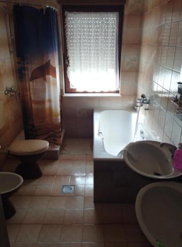 a bathroom with a tub and a sink and a toilet at Ruža in Rab