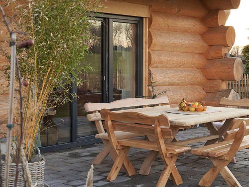 a wooden table and chairs on a patio at Ferienhaus Wiesenchalet im Sauerland in Schalksmühle