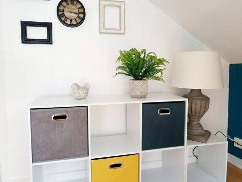 une armoire blanche avec des tiroirs colorés et une lampe dans l'établissement Chic Studio Sous Les Toits du Centre Historique, à Vannes