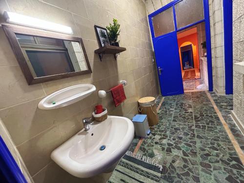 a bathroom with a sink and a blue door at Medusa Home Stay in Amman