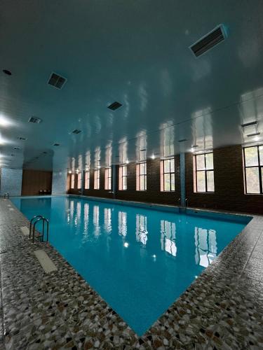 a large swimming pool with blue water in a building at Imperial Hotel in Kapan