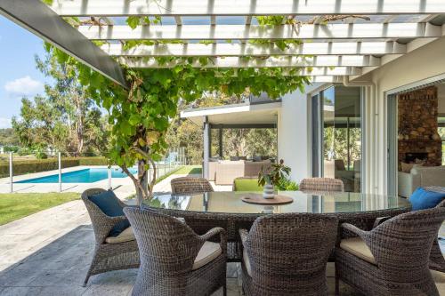 eine Terrasse mit einem Glastisch und Stühlen in der Unterkunft Marribrae I Private Properties in Yallingup