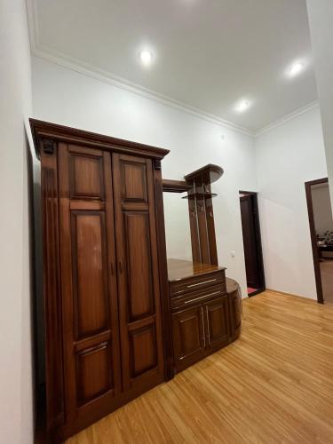 een kamer met een houten kast en een spiegel bij Imperial Hotel in Kapan